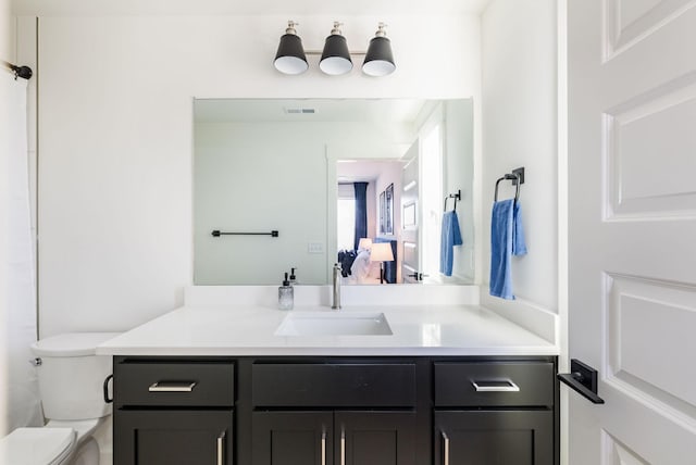 bathroom featuring vanity and toilet