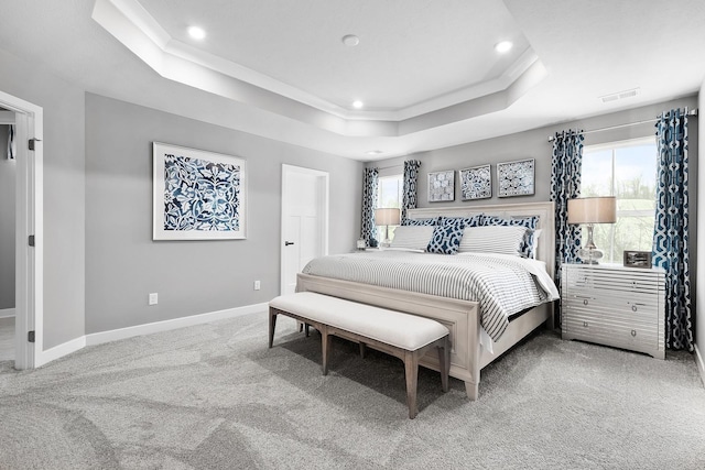 carpeted bedroom with crown molding and a tray ceiling