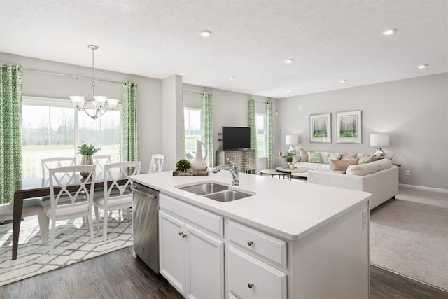 kitchen with sink, dishwasher, white cabinetry, hanging light fixtures, and an island with sink