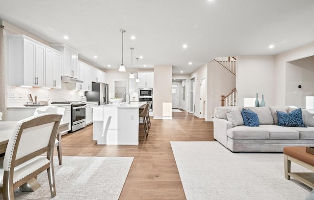 living room with sink and light hardwood / wood-style floors