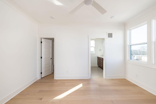 unfurnished bedroom featuring ensuite bathroom, ornamental molding, ceiling fan, and light hardwood / wood-style floors