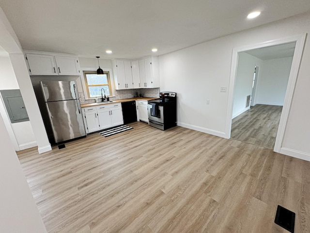 kitchen featuring butcher block countertops, sink, hanging light fixtures, stainless steel appliances, and white cabinets