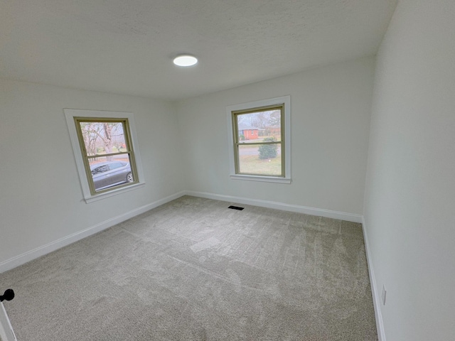 empty room featuring carpet and a textured ceiling