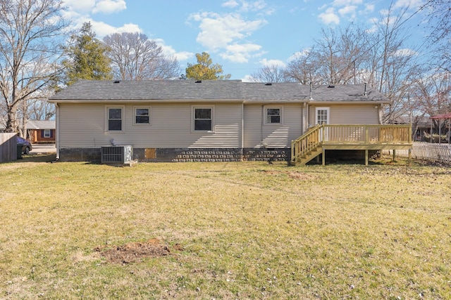 back of property with a wooden deck, central AC unit, and a lawn