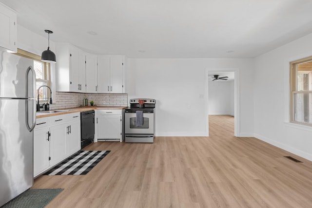 kitchen featuring stainless steel appliances, sink, hanging light fixtures, and white cabinets