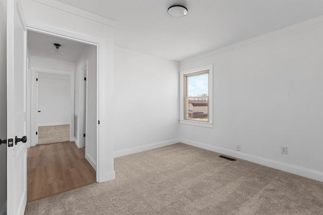 empty room featuring ornamental molding and carpet flooring