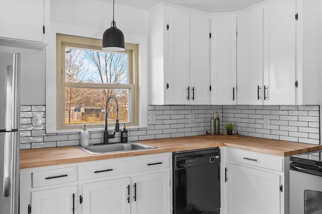 kitchen featuring butcher block counters, black dishwasher, sink, white cabinets, and hanging light fixtures