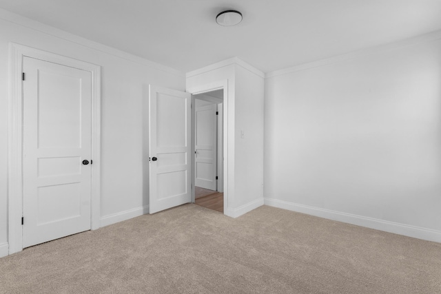 unfurnished bedroom with light colored carpet and ornamental molding