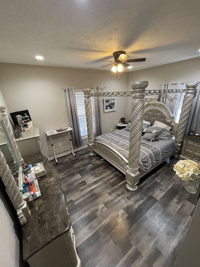 bedroom featuring dark hardwood / wood-style flooring, ceiling fan, and a textured ceiling