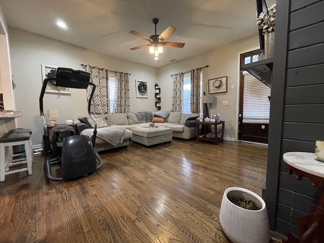 living room with dark hardwood / wood-style flooring and ceiling fan