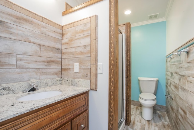 bathroom featuring crown molding, hardwood / wood-style floors, an enclosed shower, vanity, and toilet