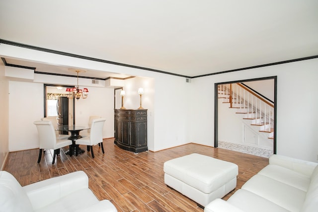 living room featuring hardwood / wood-style flooring, crown molding, and a chandelier