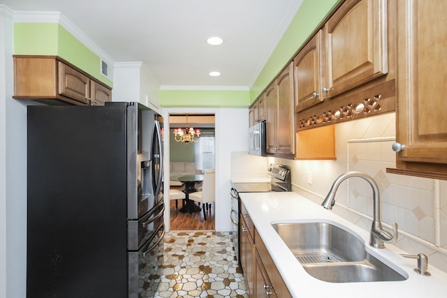 kitchen featuring crown molding, appliances with stainless steel finishes, sink, and decorative backsplash