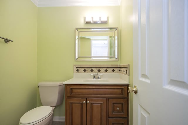 bathroom featuring tasteful backsplash, vanity, crown molding, and toilet