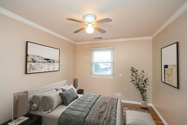 bedroom with hardwood / wood-style floors, ornamental molding, and ceiling fan