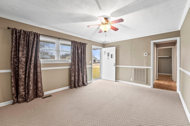 spare room featuring crown molding, ceiling fan, carpet floors, and a textured ceiling