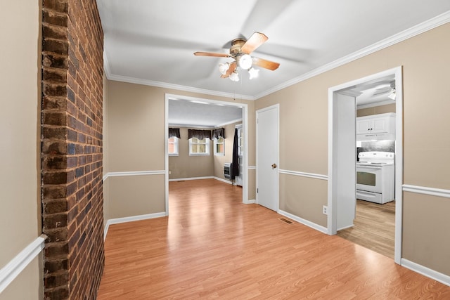 interior space with ornamental molding, ceiling fan, and light wood-type flooring