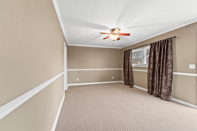 carpeted spare room with ceiling fan, ornamental molding, and a textured ceiling