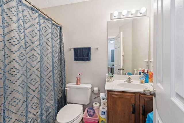 bathroom with vanity, curtained shower, and toilet