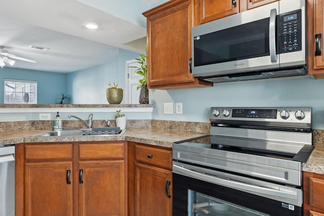 kitchen featuring appliances with stainless steel finishes, sink, and ceiling fan