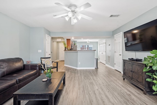 living room featuring ceiling fan and light hardwood / wood-style flooring