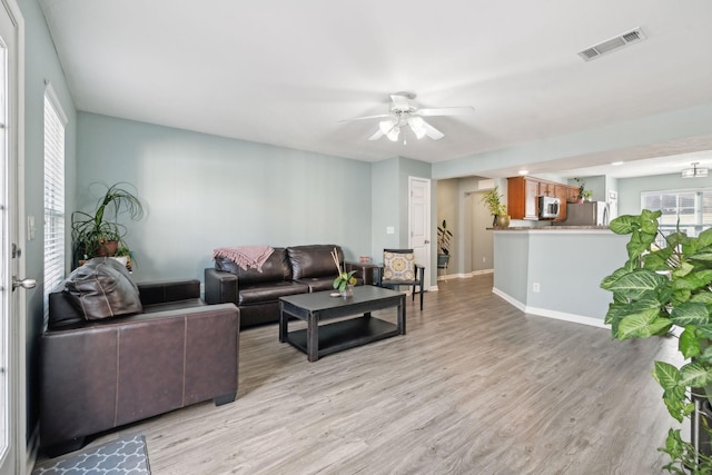 living room with ceiling fan and light hardwood / wood-style floors