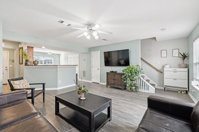 living room featuring light hardwood / wood-style flooring and ceiling fan