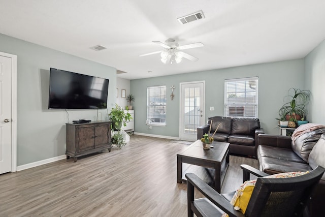 living room featuring wood-type flooring and ceiling fan