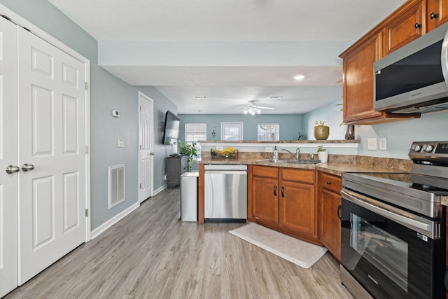 kitchen featuring sink, light hardwood / wood-style flooring, ceiling fan, stainless steel appliances, and kitchen peninsula