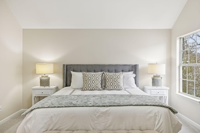 bedroom with light colored carpet and lofted ceiling