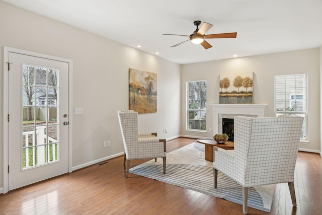 sitting room with ceiling fan, a healthy amount of sunlight, and light hardwood / wood-style flooring