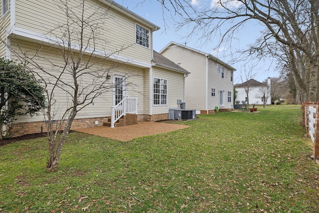 back of property featuring a lawn and central air condition unit