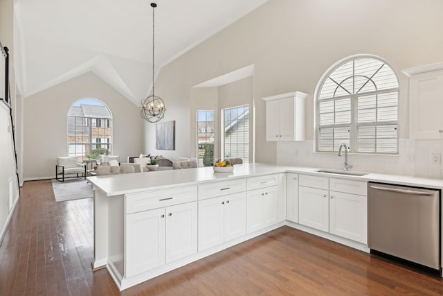 kitchen featuring sink, decorative light fixtures, stainless steel dishwasher, kitchen peninsula, and white cabinets