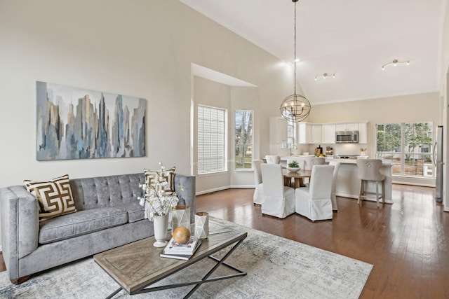 living room with high vaulted ceiling, a notable chandelier, and dark hardwood / wood-style flooring