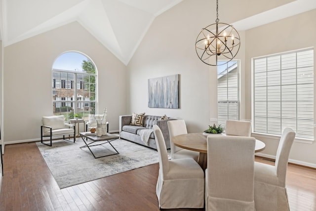 dining area featuring a notable chandelier, hardwood / wood-style flooring, and high vaulted ceiling