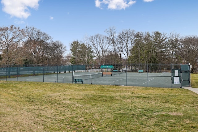 view of tennis court featuring a lawn