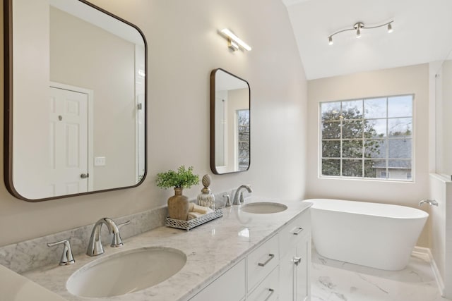 bathroom with lofted ceiling, a bathing tub, and vanity