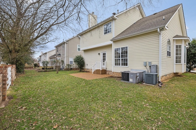 back of house with central AC and a lawn