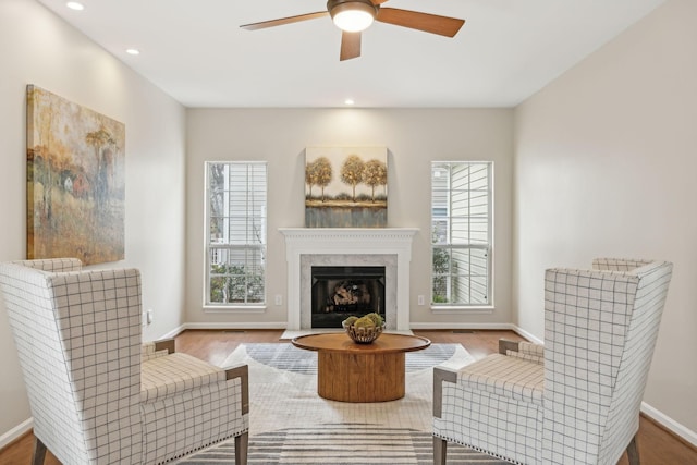 sitting room with light hardwood / wood-style flooring, a fireplace, and ceiling fan