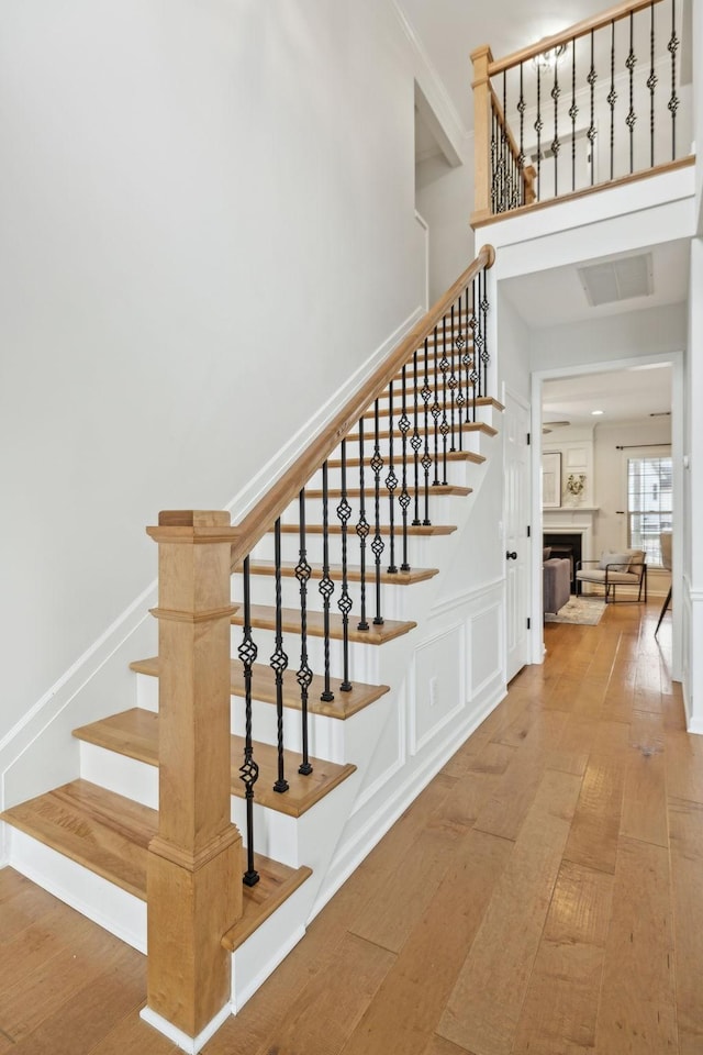 stairs with wood-type flooring and a high ceiling