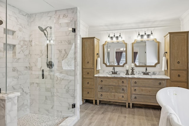 bathroom featuring crown molding, wood-type flooring, shower with separate bathtub, and vanity