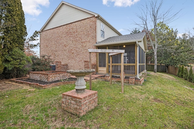 rear view of property featuring a lawn and a sunroom