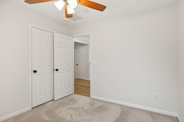 unfurnished bedroom with ceiling fan, a closet, and light carpet