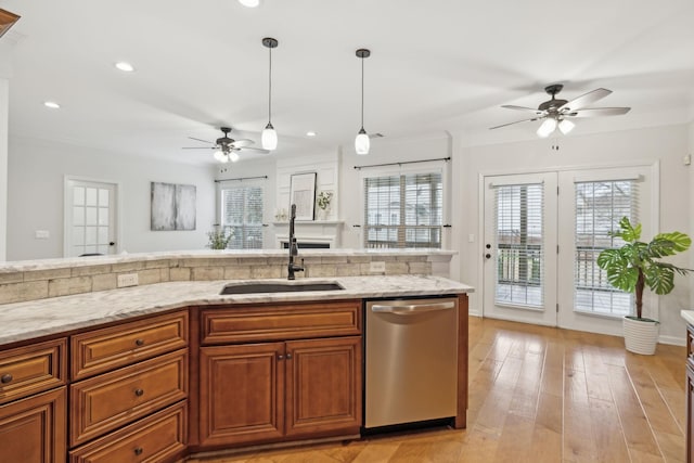 kitchen with sink, hanging light fixtures, stainless steel dishwasher, light hardwood / wood-style floors, and crown molding