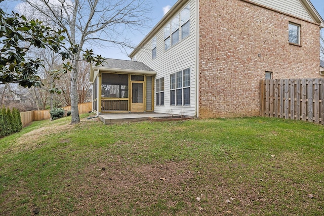 rear view of house with a yard, a patio, and a sunroom