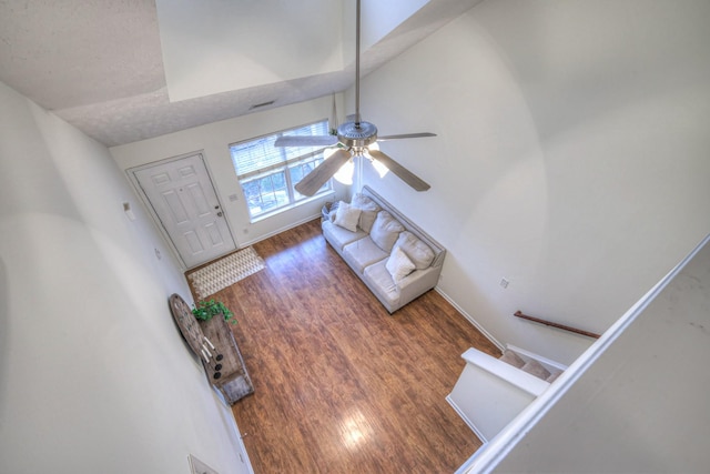 unfurnished living room with ceiling fan, dark wood-type flooring, and a textured ceiling