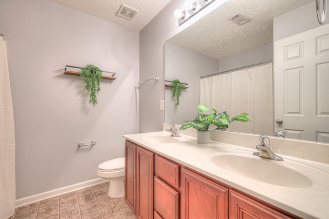 bathroom with vanity, a textured ceiling, and toilet