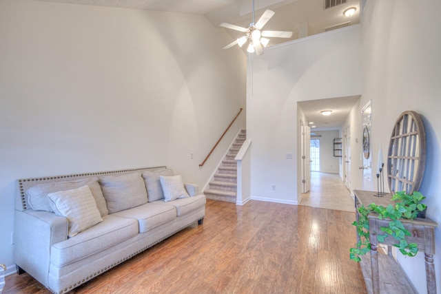 living room with hardwood / wood-style floors, high vaulted ceiling, and ceiling fan