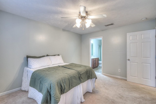 carpeted bedroom featuring ceiling fan, connected bathroom, and a textured ceiling