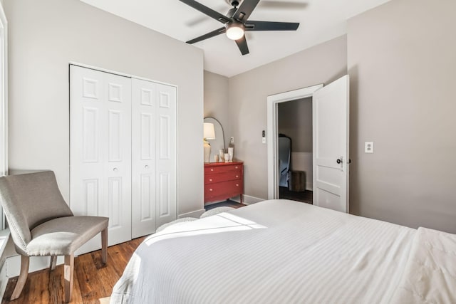 bedroom with dark wood-type flooring, ceiling fan, and a closet